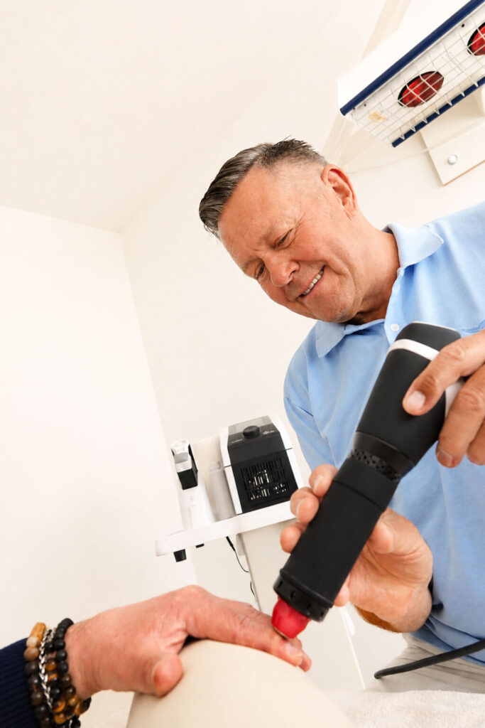 Stoßwellentherapie am Knie mit dem Handstück des Geräts